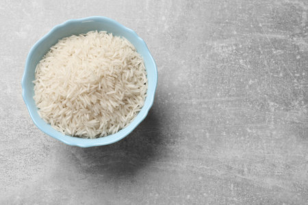 Raw basmati rice in bowl on gray table, top view. Space for textの写真素材