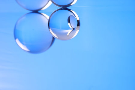 Transparent glass balls on blue background. Space for textの写真素材