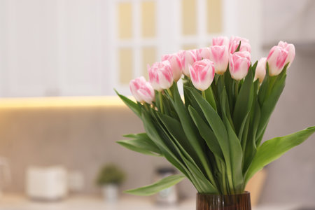Beautiful bouquet of fresh pink tulips in kitchen. Space for textの写真素材