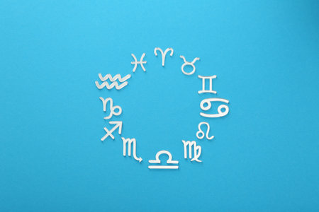 Zodiac signs on light blue background, flat lay