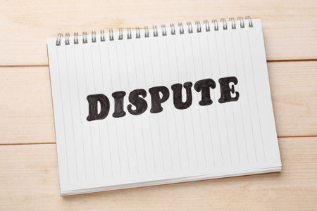 Notebook with word Dispute on wooden table, top viewの写真素材