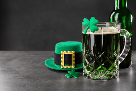St. Patrick's day celebration. Green beer, leprechaun hat and decorative clover leaves on gray...