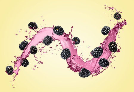 Fresh blackberries and juice in air on pastel yellow backgroundの写真素材