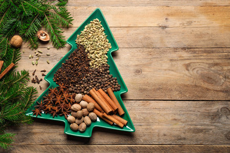 Different spices, nuts and fir branches on wooden table, flat lay. Space for textの写真素材