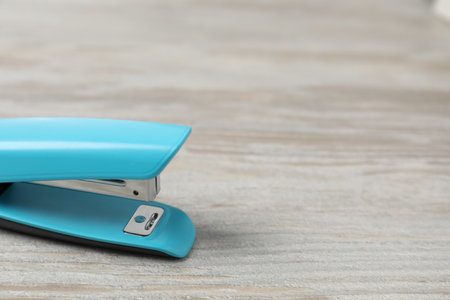 One light blue stapler on wooden table, closeup. Space for textの写真素材