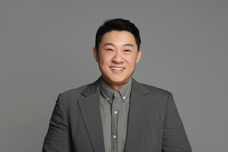 Portrait of happy businessman on gray background