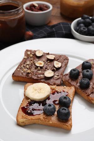Different tasty toasts with nut butter and products on table, closeupの写真素材