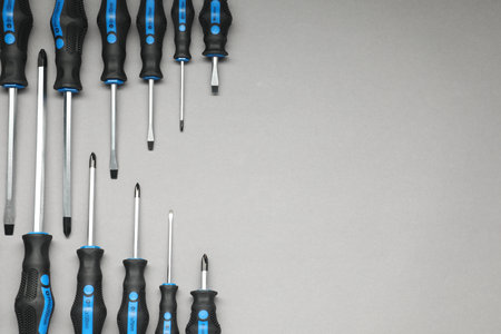 Set of screwdrivers on gray background, flat lay. Space for textの写真素材