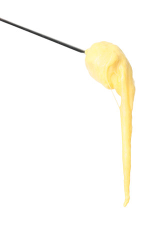 Tasty fondue. Fork with piece of ham and melted cheese isolated on whiteの写真素材