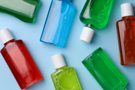 Fresh mouthwashes in bottles on light blue background, flat layの写真素材