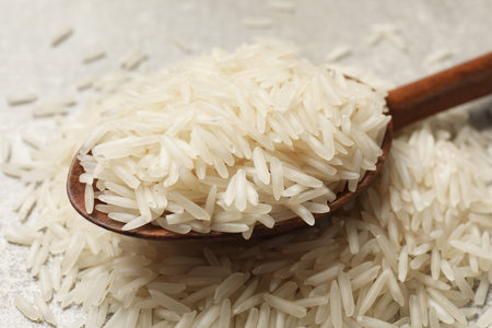 Raw basmati rice and wooden spoon on table, closeupの写真素材