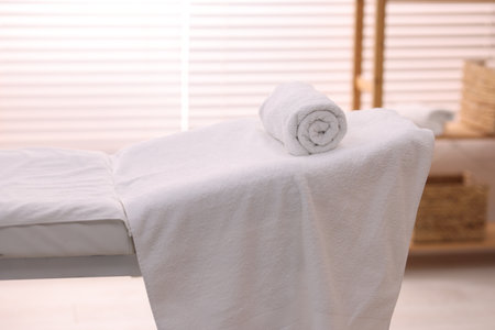 Rolled towel on massage table in spa centerの写真素材
