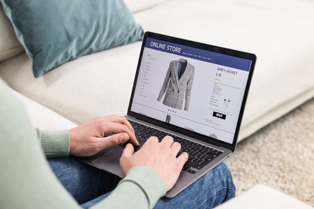 Man with laptop shopping online indoors, closeupの写真素材