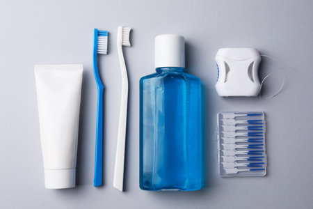Flat lay composition with fresh mouthwash in bottle and other oral care products on gray backgroundの写真素材