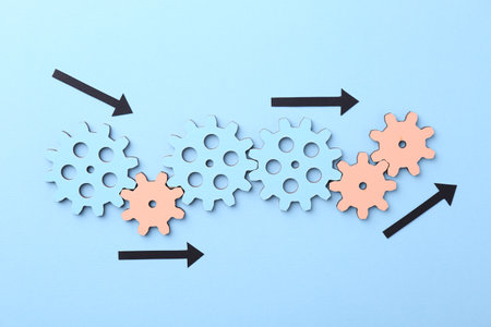 Business process organization and optimization. Scheme with wooden figures and arrows on light blue background, top viewの写真素材