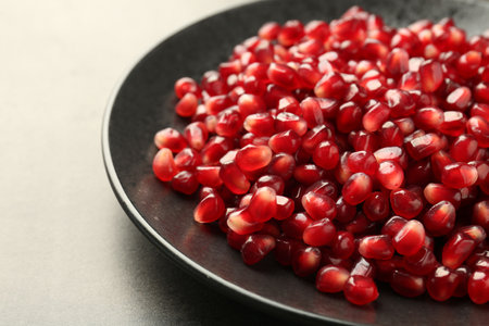 Ripe juicy pomegranate grains on gray table, closeupの写真素材