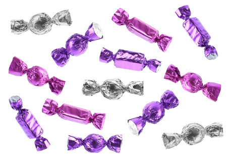 Tasty candies in bright wrappers falling on white backgroundの写真素材