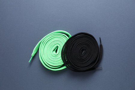 Stylish black and green shoe laces on gray background, top viewの写真素材