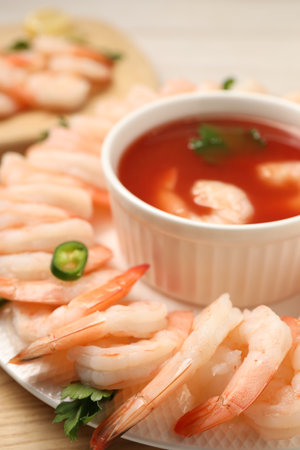 Tasty boiled shrimps with sauce cocktail, chili and parsley on light wooden table, closeupの写真素材