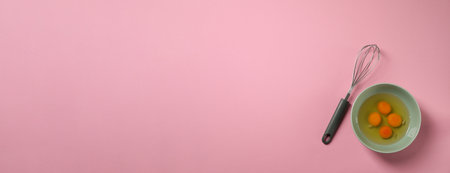 Metal whiskey and raw eggs in bowl on pink background, top view. Banner design with space for textの写真素材