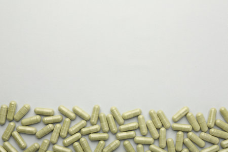Vitamin capsules on light gray background, top view and space for text. Health supplementの写真素材