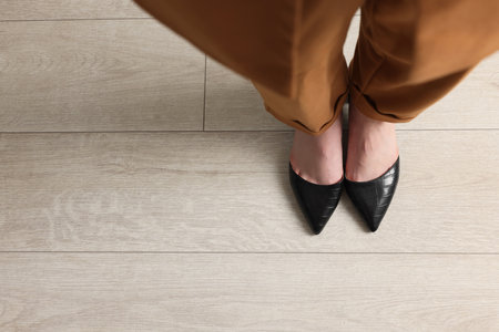 Businesswoman in leather shoes on floor, above view. Space for textの写真素材