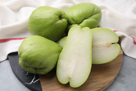 Cut and whole chayote on gray table, closeupの写真素材