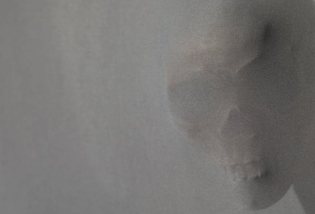 Silhouette of creepy ghost with skull behind cloth, space for textの写真素材