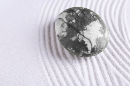 Zen concept. Stone and pattern on white sand, closeup. Space for textの写真素材