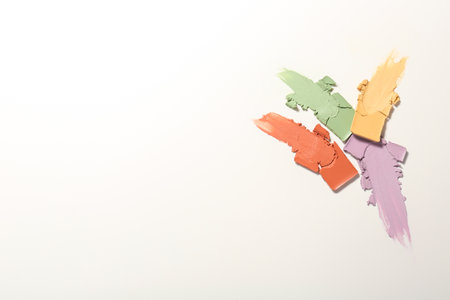 Samples of different color correcting concealers on white background, top viewの写真素材