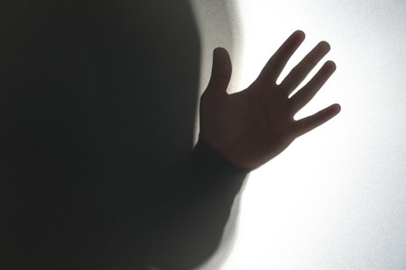 Silhouette of ghost behind glass against white background, closeupの写真素材