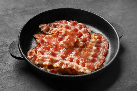 Fried bacon slices on dark textured table, closeupの写真素材