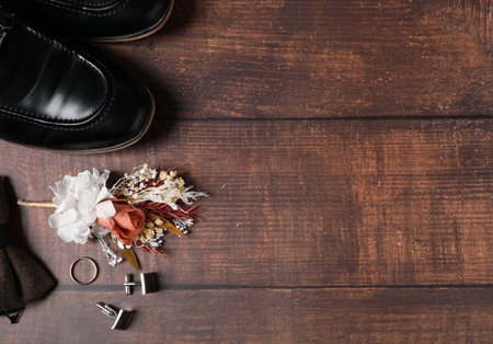Wedding stuff. Flat lay composition with stylish boutonniere on wooden background, space for textの写真素材