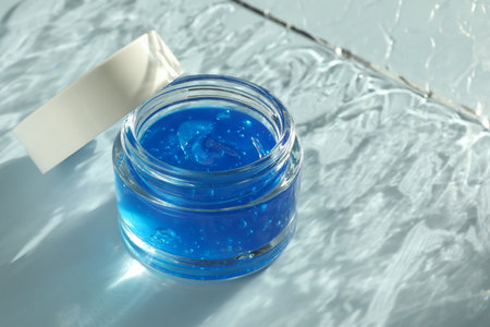 Open jar of cosmetic product on light blue background, space for textの写真素材