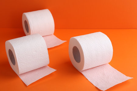 Soft toilet paper rolls on orange backgroundの写真素材
