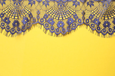 Blue lace on yellow background, top view. Space for textの写真素材