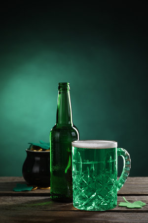 St. Patrick's day party. Green beer, leprechaun pot of gold and decorative clover leaves on wooden tableの写真素材