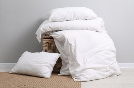 Soft pillows, duvet and wicker trunk indoorsの写真素材