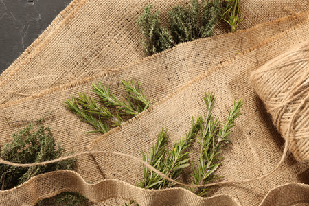 Natural burlap fabric, jute and fresh herbs on table, top viewの写真素材