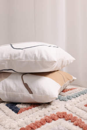 Stacked soft pillows on floor in roomの写真素材
