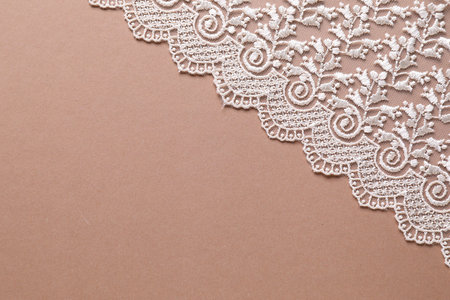 White lace on beige background, top view. Space for textの写真素材