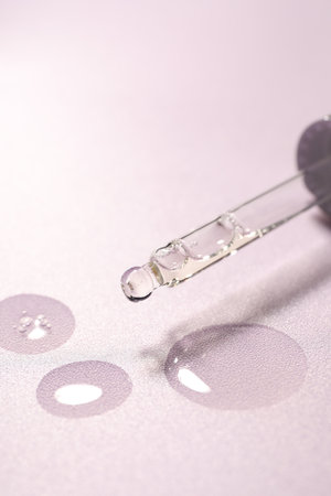 Pipette and moisturizing serum on light violet background, closeupの写真素材