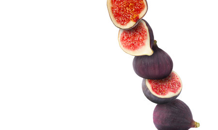 Stacked ripe fresh figs on white background