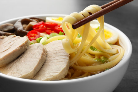 Noodle soup. Eating delicious ramen with chopsticks at table, closeupの写真素材
