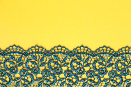 Green lace on yellow background, top view. Space for textの写真素材