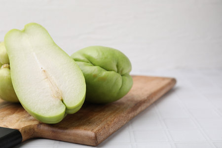 Cut and whole chayote on white tiled table, closeupの写真素材