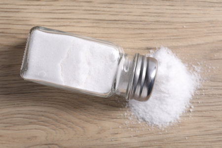 Natural salt in shaker on wooden table, top viewの写真素材