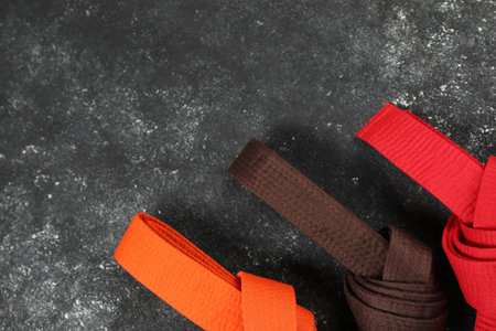 Colorful karate belts on gray background, flat lay. Space for textの写真素材