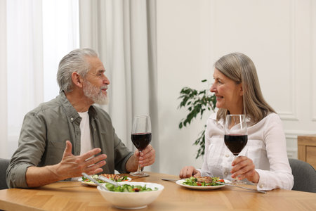 Happy senior couple having romantic dinner at homeの写真素材