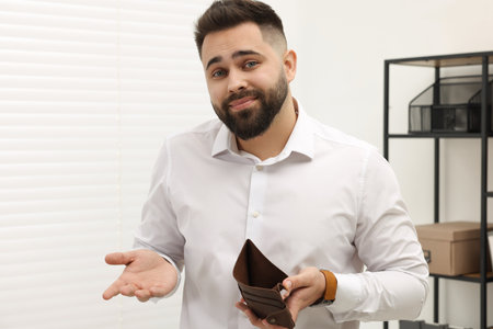 Upset man with empty wallet in office